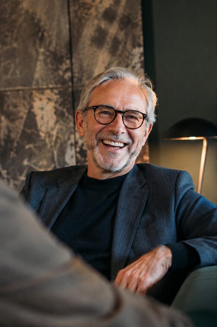 A confident executive laughing in conversation, at ease and in control
